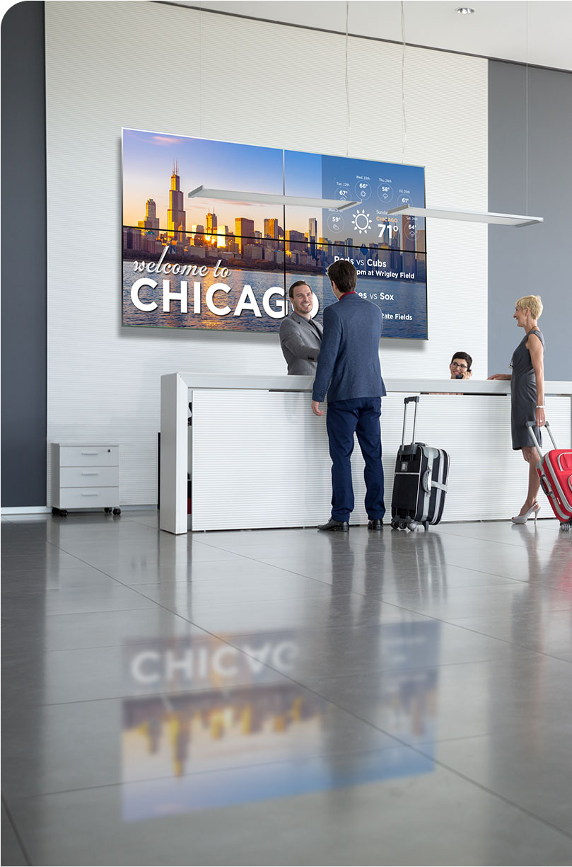 guests in a hotel lobby with digital signage screen